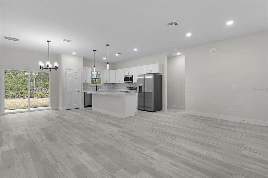 Looking from the living area into the kitchen and dining areas, with sliding door onto the covered rear lanai