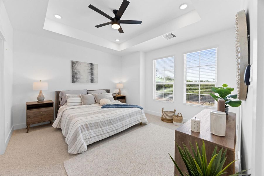 Step into this spacious primary bedroom featuring a luxurious en-suite bath, walk-in closet, and large windows that flood the space with natural light. Ceiling fans are not included. Step into this spacious primary bedroom featuring a luxurious en-suite bath, walk-in closet, and large windows that flood the space with natural light. Ceiling fans are not included.