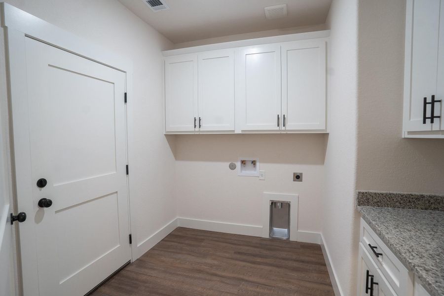 Laundry area with cabinet space, electric dryer hookup, hookup for a washing machine, dark wood-style flooring, and baseboards