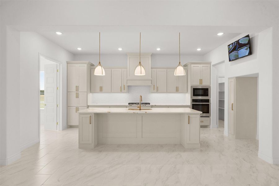 Kitchen with decorative light fixtures, stainless steel appliances, a kitchen island with sink, light stone counters, and a breakfast bar area