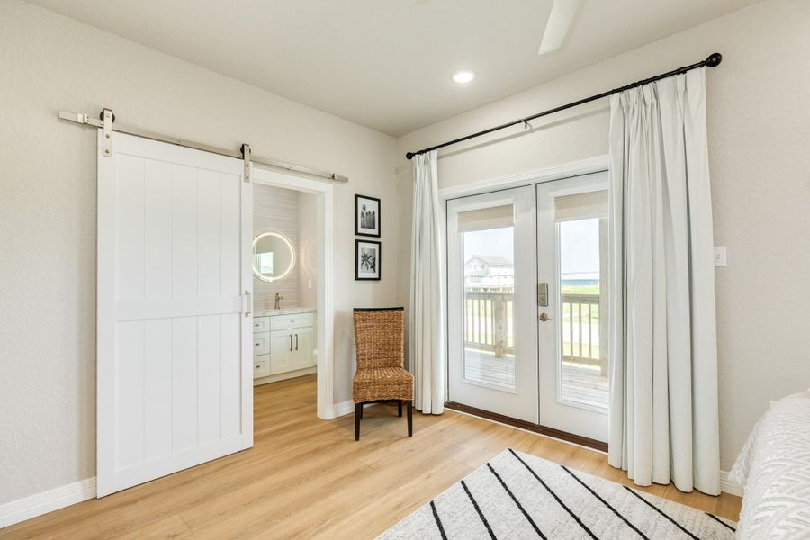 The primary suite offers direct access to the covered balcony and a private en-suite bath, creating a relaxing retreat with indoor-outdoor appeal.