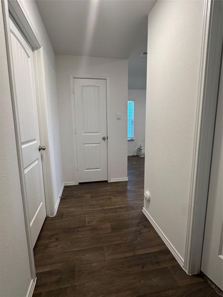 Hallway featuring dark wood-type flooring and baseboards