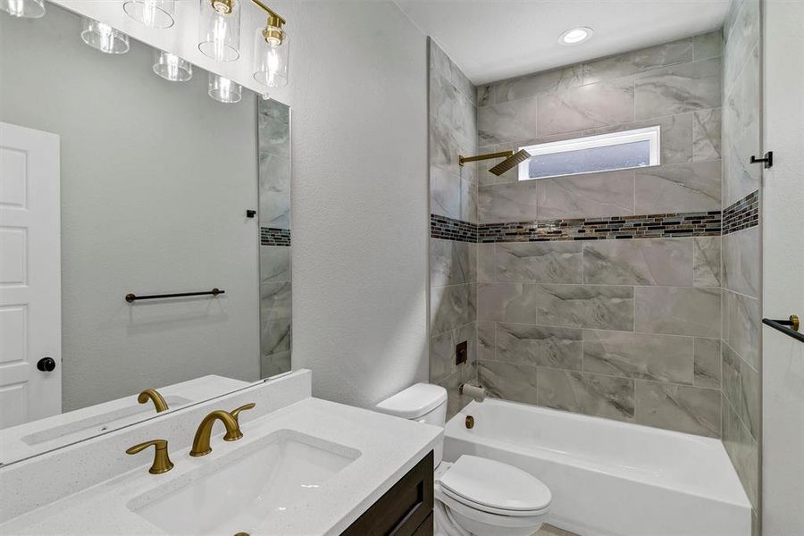 Full bathroom featuring vanity, toilet, and tiled shower / bath