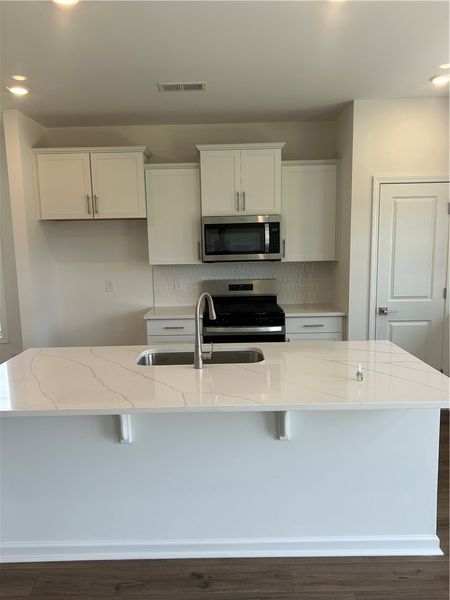 Modern kitchen with sleek white cabinetry and buil