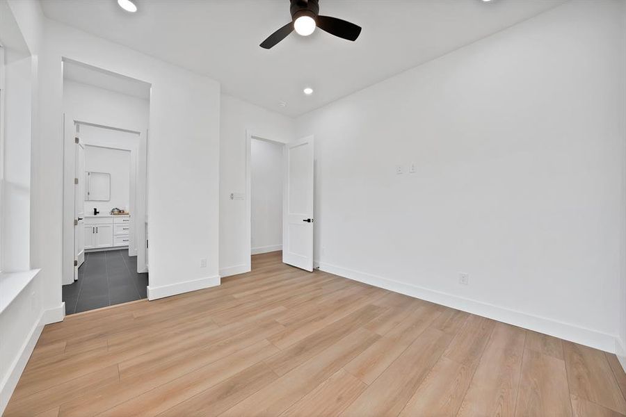 Spacious room featuring wood-finish flooring and a contemporary ceiling fan