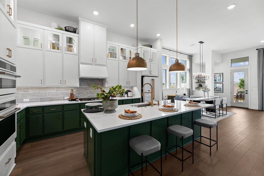 Two tone kitchen with dual tone cabinetry, a breakfast bar, dark wood-style flooring, decorative backsplash, and stainless steel appliances Two tone kitchen with dual tone cabinetry, a breakfast bar, dark wood-style flooring, decorative backsplash, and stainless steel appliances