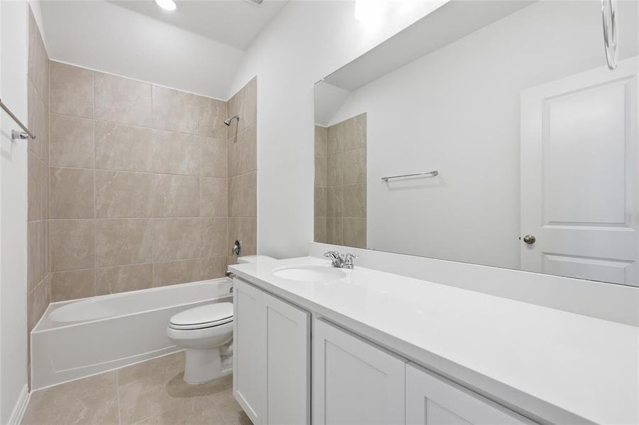 Full bath featuring vanity, bathing tub / shower combination, and light tile patterned floors