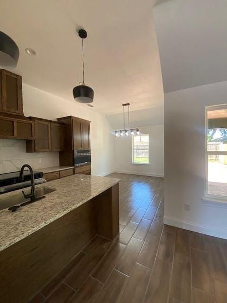 Kitchen featuring a wealth of natural light, a sink, pendant lighting, and baseboards
