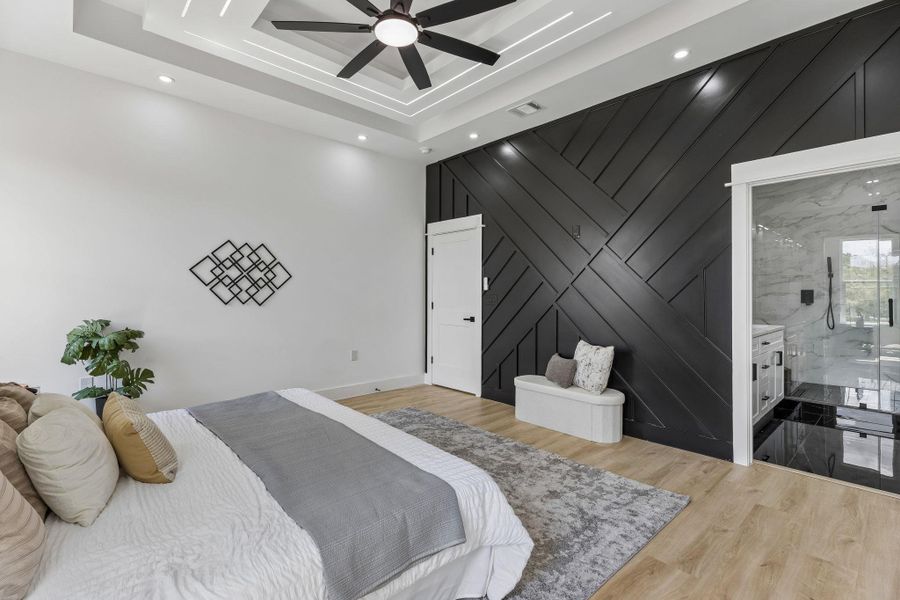 Striking architectural details define this serene space featuring warm wood flooring and integrated ensuite access.