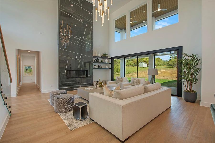 Living room with a towering ceiling, a tile fireplace, and hardwood / wood-style flooring