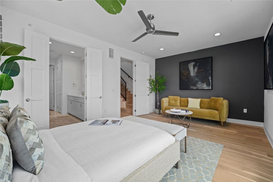 Spacious room featuring wood-finish flooring, a contemporary ceiling fan, recessed lighting, and a dark accent wall