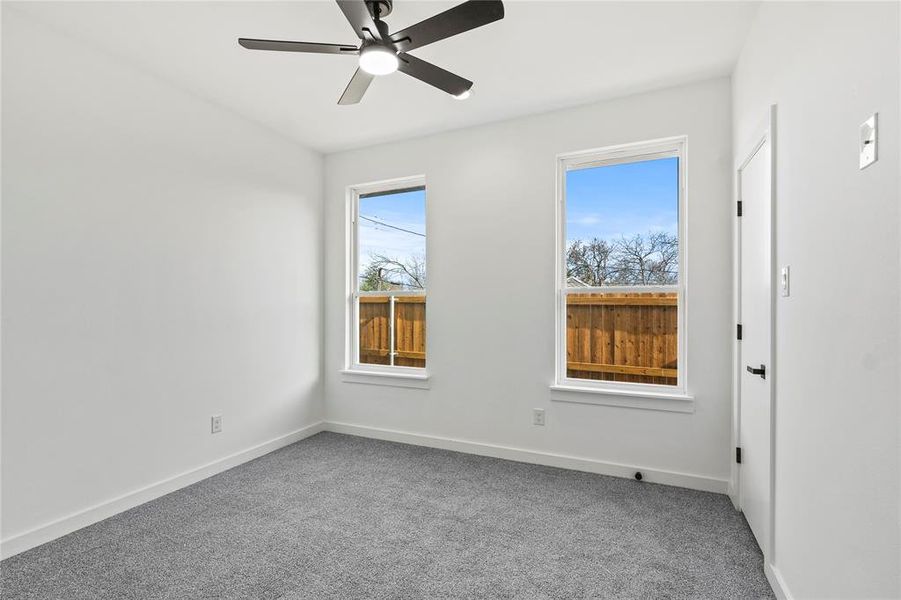 Empty room featuring carpet flooring and ceiling fan