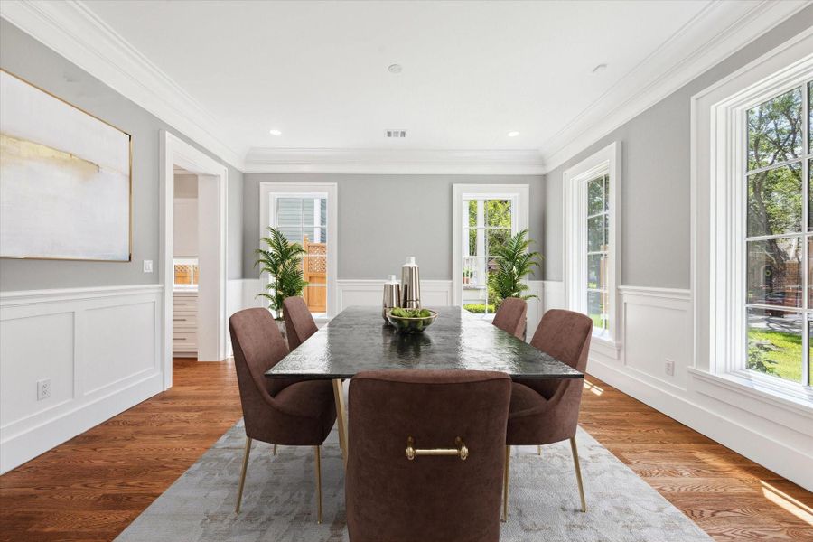 The light filled formal dining room has custom designed wainscotting and crown molding,  high ceilings, beautiful hardwood floors and four full length windows!  This is the ideal place for family dinners or festive parties!  This photo has been virtually staged.