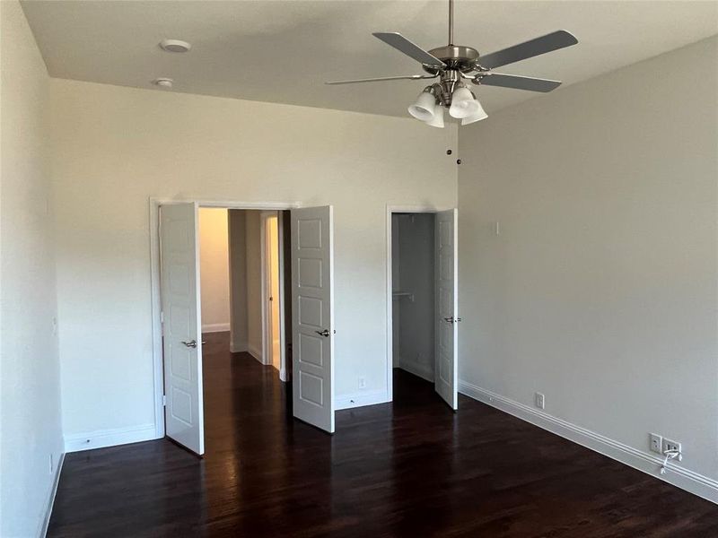 Unfurnished bedroom featuring ceiling fan and dark hardwood / wood-style flooring