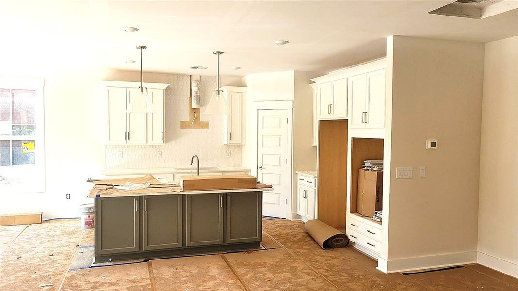 White cabinetry and a contrast-tone island frame t White cabinetry and a contrast-tone island frame t