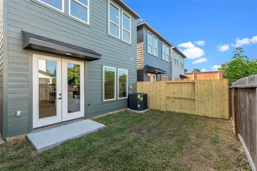Modern townhouse with a private fenced backyard, featuring a patio and French doors for seamless indoor-outdoor living. Modern townhouse with a private fenced backyard, featuring a patio and French doors for seamless indoor-outdoor living.
