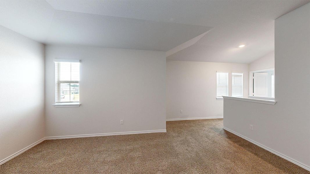 Unfurnished room with vaulted ceiling and light carpet