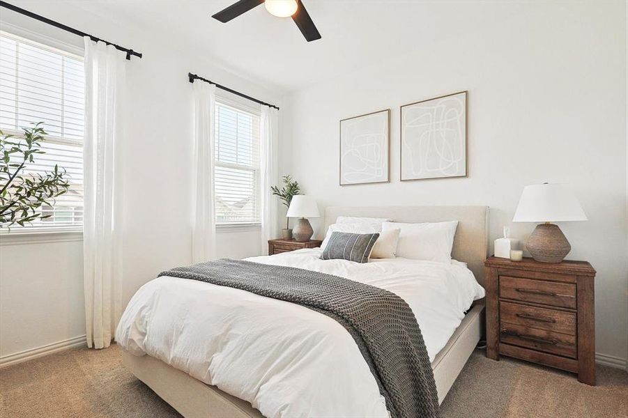 Carpeted bedroom featuring ceiling fan