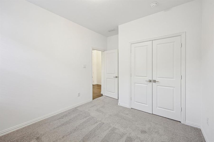 Unfurnished bedroom featuring light carpet and a closet