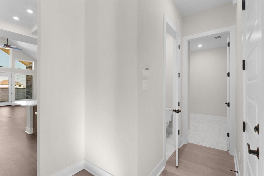 Hallway with light wood-style floors and recessed lighting