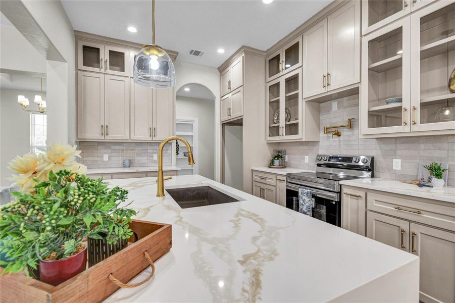 Kitchen view, island with waterfall quartz countertops Kitchen view, island with waterfall quartz countertops