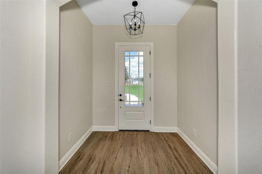 Entryway featuring hardwood / wood-style flooring and a notable chandelier