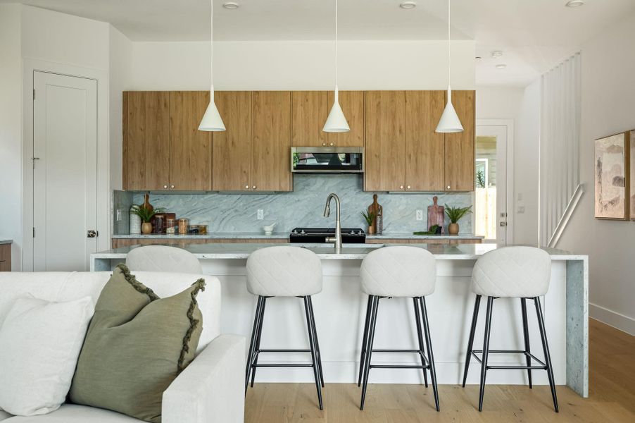 An inviting eat-in kitchen with a kitchen island features stainless steel appliances and pendant lighting. An inviting eat-in kitchen with a kitchen island features stainless steel appliances and pendant lighting.