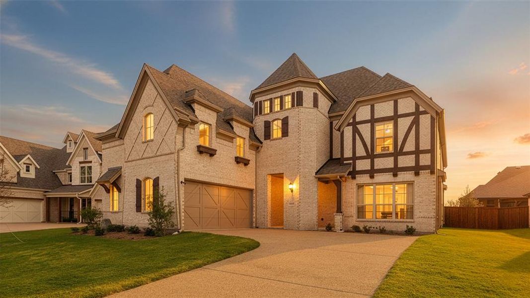 Tudor-style house featuring brick siding, concrete driveway, a shingled roof, and a garage Tudor-style house featuring brick siding, concrete driveway, a shingled roof, and a garage