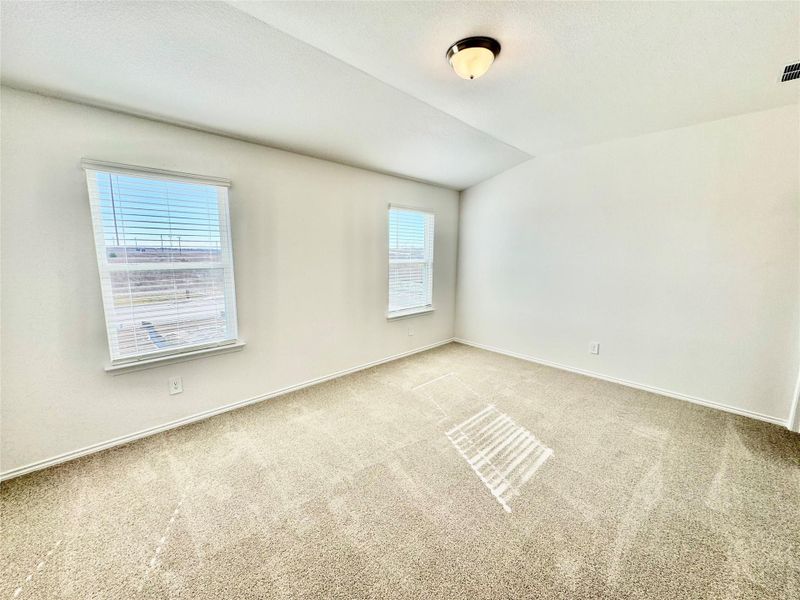 Unfurnished room with carpet floors and vaulted ceiling