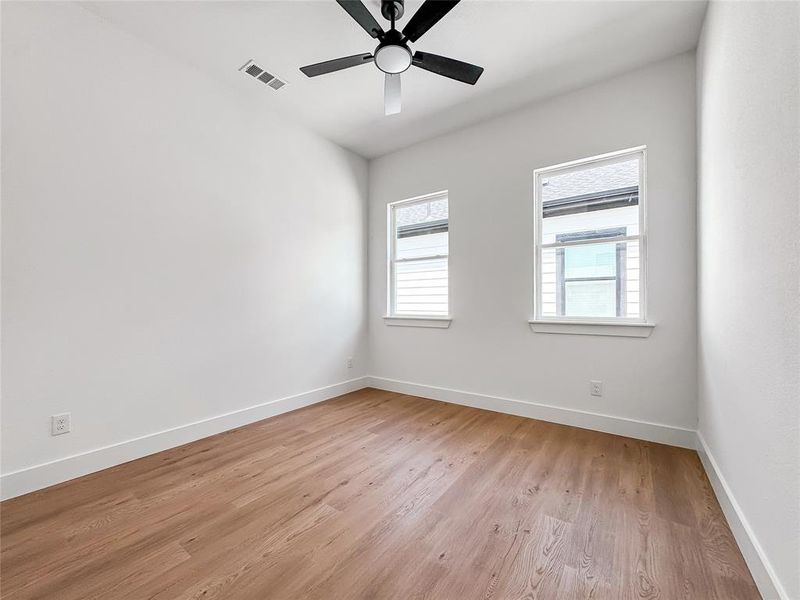 Unfurnished room with light wood finished floors, baseboards, and ceiling fan