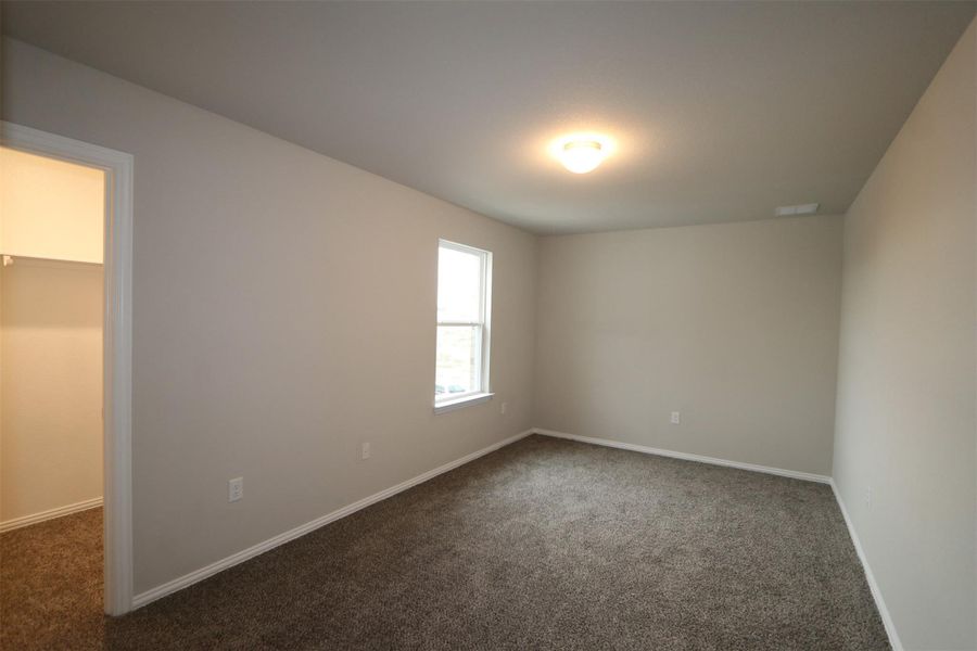 Unfurnished room featuring dark colored carpet