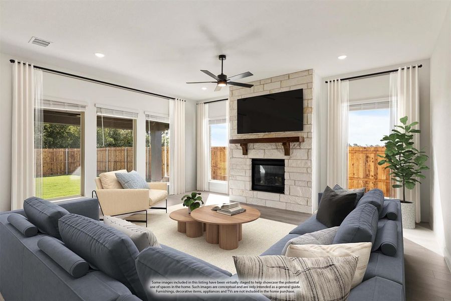 Living room with stone fireplace, ceiling fan, large windows, and gray sectional sofa Living room with stone fireplace, ceiling fan, large windows, and gray sectional sofa