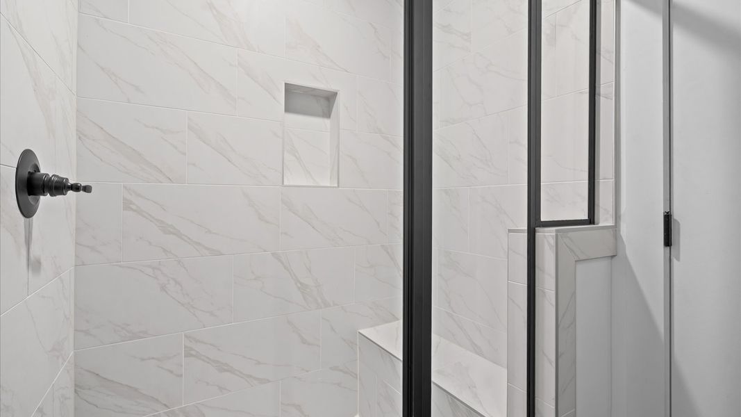 Memorable mornings begin in this elegant primary bathroom with tiled walk-in shower & double vanity Memorable mornings begin in this elegant primary bathroom with tiled walk-in shower & double vanity