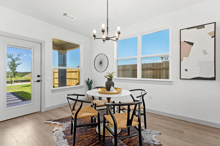 Dining area featuring a chandelier, plenty of natural light, and light wood-style floors Dining area featuring a chandelier, plenty of natural light, and light wood-style floors