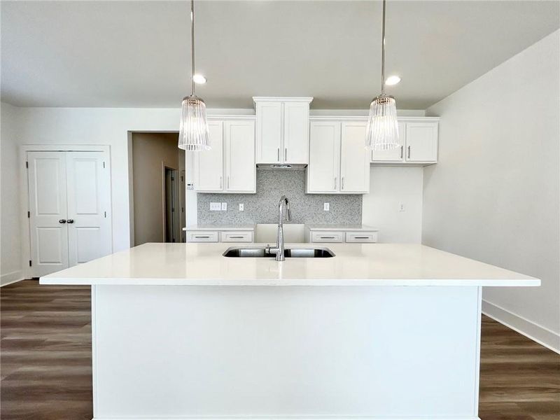 Kitchen with an island with sink and pendant lighting