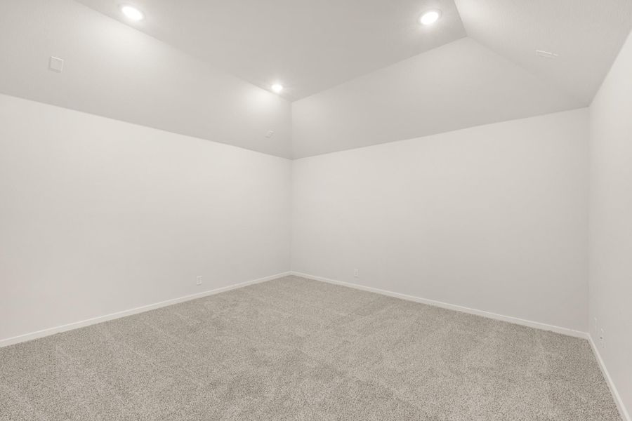 Empty room with white walls, gray carpet, and recessed ceiling lights