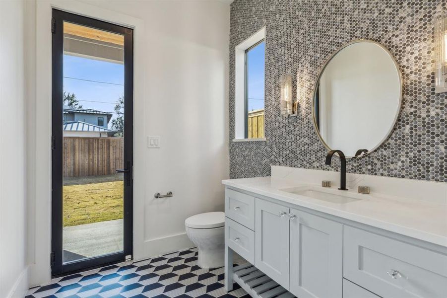 Bathroom with a wealth of natural light, vanity, and toilet