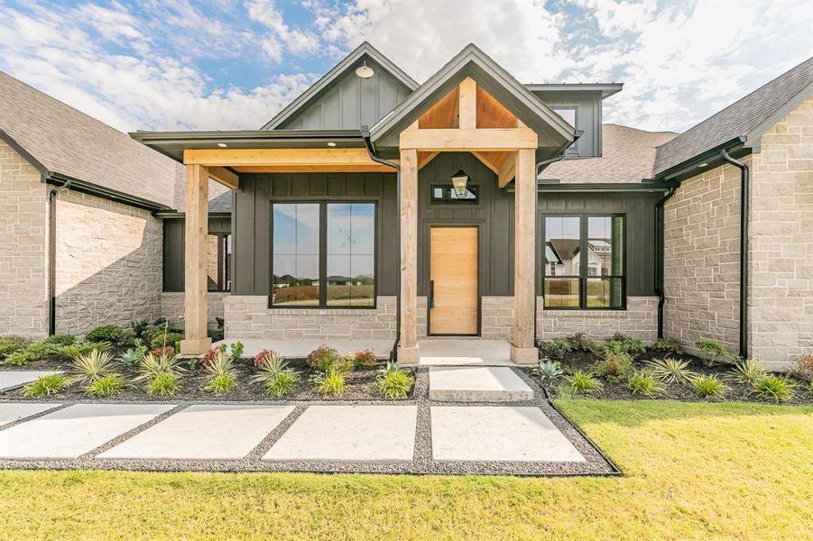 Entrance with architectural design elements and a large front porch for rocking chairs and visiting with neighbors, board and batten, and austin stone.
