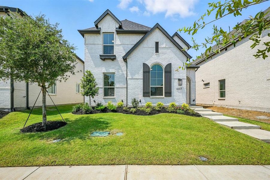French provincial home with a front yard, brick siding, and roof with shingles French provincial home with a front yard, brick siding, and roof with shingles
