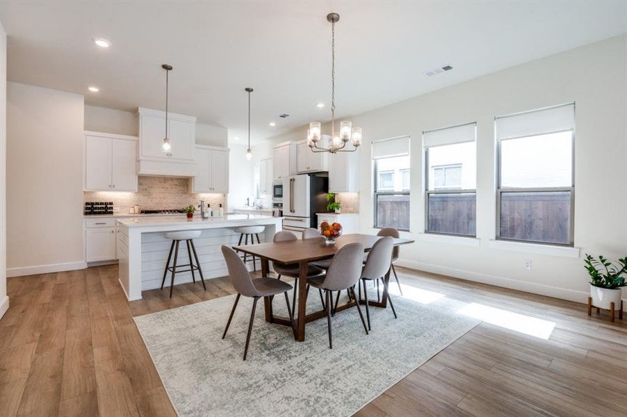 Dining space featuring a chandelier, light wood-type flooring, and recessed lighting Dining space featuring a chandelier, light wood-type flooring, and recessed lighting