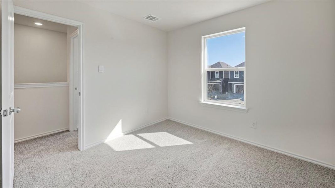 Unfurnished bedroom with light carpet and baseboards