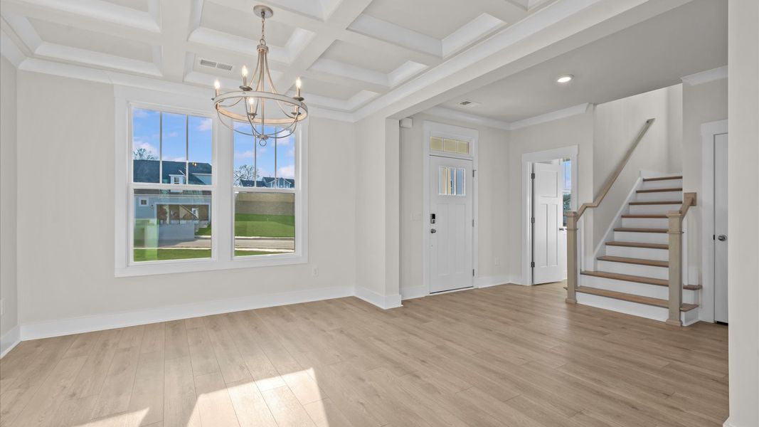 Accomplished dining room featuring coffered ceiling and stylish lighting for a timeless look