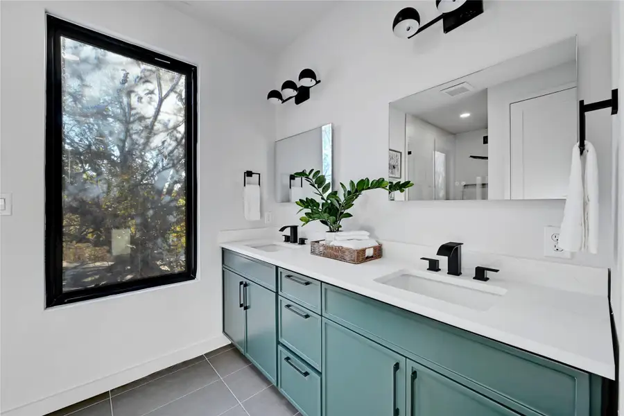 Bathroom with tile patterned floors, visible vents, a shower stall, and a sink