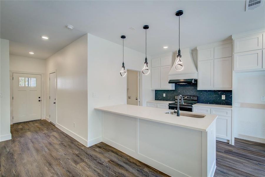 Kitchen featuring backsplash, white cabinets, premium range hood, black electric range, and recessed lighting Kitchen featuring backsplash, white cabinets, premium range hood, black electric range, and recessed lighting