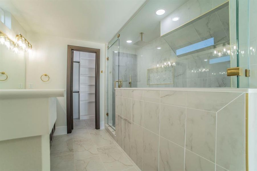 Full bathroom featuring a marble finish shower, marble look tile flooring, vanity, a walk in closet, and recessed lighting Full bathroom featuring a marble finish shower, marble look tile flooring, vanity, a walk in closet, and recessed lighting