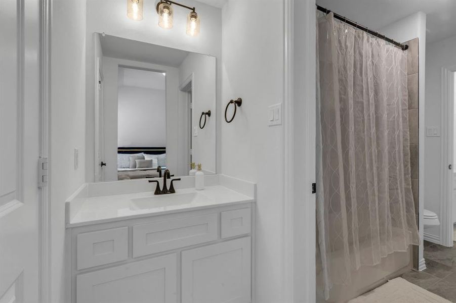 Bathroom with toilet, vanity, and tile patterned floors