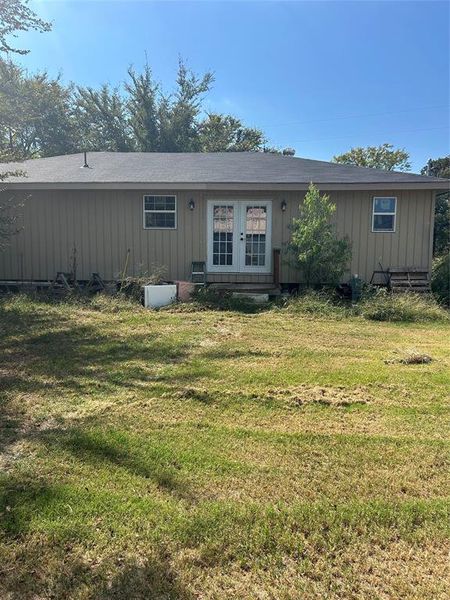 Back of house featuring a yard and french doors