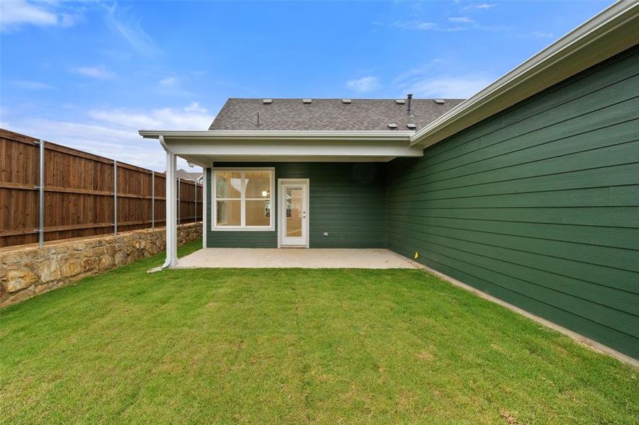 Back of house featuring a lawn and a patio