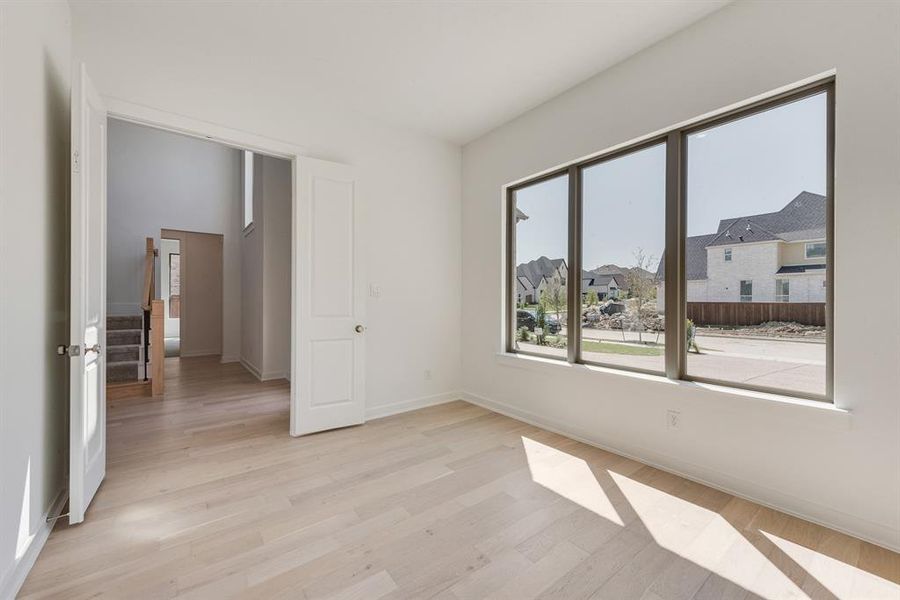 Spare room featuring light wood-type flooring and a residential view Spare room featuring light wood-type flooring and a residential view