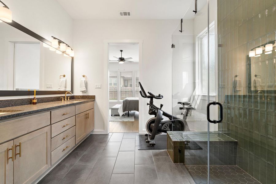 Dual sink vanity with gold-tone fixtures and light wood-finish cabinetry